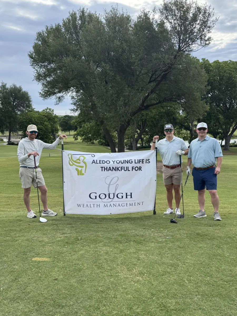 Gough Wealth Management poses with a sponsorship sign at a golf tournament for Aledo Young Life