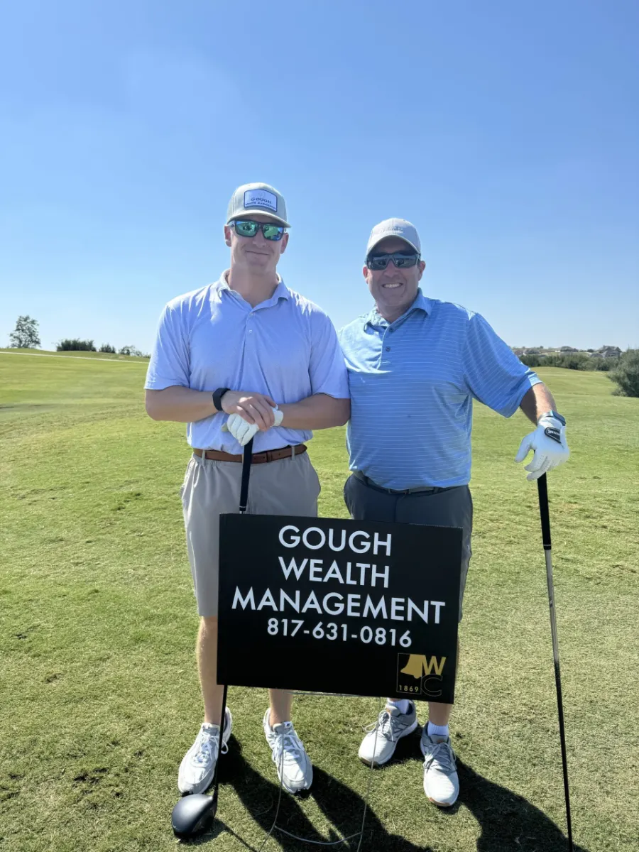 Part of the Gough Wealth Management team poses with a sponsorship sign at a charity golf tournament